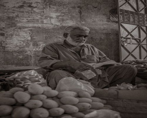 A Pakistani man picking fresh vegetables from a local market